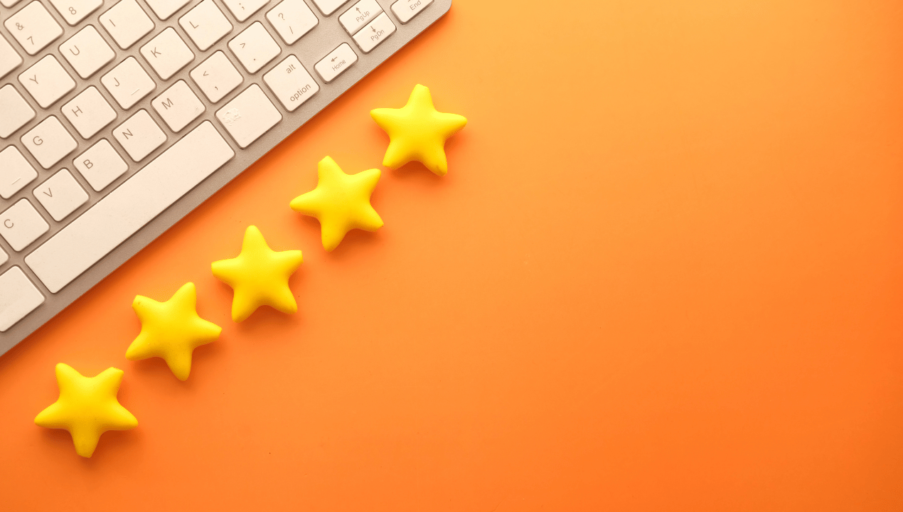Five yellow star shapes lined up next to a keyboard on an orange background